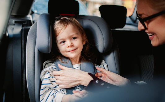 Enfant dans le siege auto et sa maman lui sourit